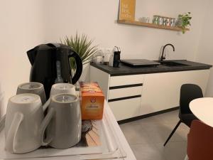 eine Küche mit einer Arbeitsfläche, auf der eine Kaffeemaschine steht, und einem Kühlschrank in der Unterkunft Appartamento 21 - Smart Apartment nel centro di Segusino, vicino le colline del Prosecco in Sequsino