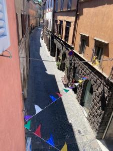 an alley with flags on a clothes line in a city at Alloggio Turistico LA TORRE in Acquapendente +2 photos