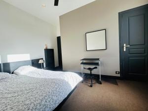a bedroom with a bed and a desk next to a door at Casa Volney in Angers