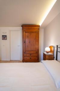 a bedroom with a bed and a wooden cabinet at Torretta dependance in Assisi