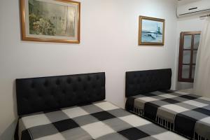 two beds in a room with a checkered floor at Itaparica - Praia de Ponta de Areia in Itaparica Town +12 photos