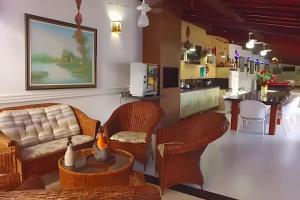 a living room with a couch and chairs and a kitchen at Itaparica - Praia de Ponta de Areia in Itaparica Town