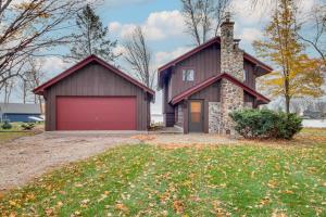 a house with a red garage in front of it at Mille Lacs Lake Retreat! Cabin with Private Dock in Bayview