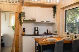 a kitchen with white cabinets and a wooden table at Nature Living Koralpe in Sankt Stefan im Lavanttal +37 photos