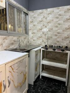 een keuken met een fornuis en een spoelbak bij Tataicha Stydio 1 in Ndjamena