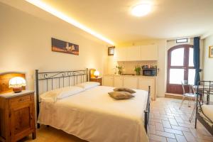 a bedroom with a large bed and a kitchen at Torretta dependance in Assisi +18 photos