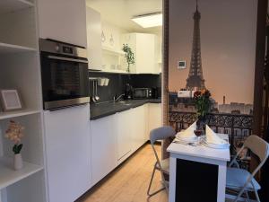 een keuken met een tafel en de Eiffeltoren bij Holiday & Stay, Tiny living in Fronreute +24 foto's