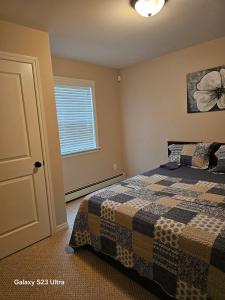 un dormitorio con una cama y una ventana en Cozy, Private Basement Suite, en Halifax