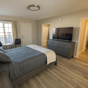 a bedroom with a bed and a flat screen tv at Empire Extended Stay in Webster