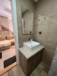 a bathroom with a sink and a mirror at Amprtman PETKOVIĆ NLux 110 Milmari resort in Kopaonik