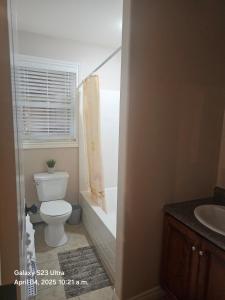 Un baño con inodoro, bañera y lavabo. en Cozy, Private Basement Suite, en Halifax 32 fotos más