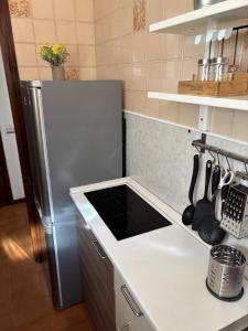 eine Küche mit einem Kühlschrank und einer weißen Arbeitsplatte in der Unterkunft Novate Fiera in Novate Milanese