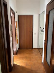 einen Flur mit Holztür und Fliesenboden in der Unterkunft Novate Fiera in Novate Milanese