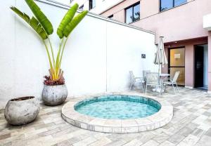 a small pool with a plant in a courtyard at Bela Vista São Paulo "Apto moderno, confortável e proximo a varios pontos turistico" in Sao Paulo