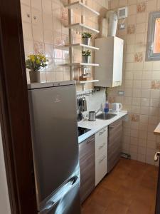 eine kleine Küche mit einem Kühlschrank aus Edelstahl in der Unterkunft Novate Fiera in Novate Milanese + 23 Fotos