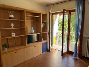 a kitchen with wooden shelves and a sliding glass door at Novate Fiera in Novate Milanese
