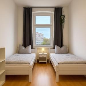 una habitación con dos camas y una ventana en YourFavoriteBed Designwohnung Nähe Zentrum und Klinikum, en Plauen