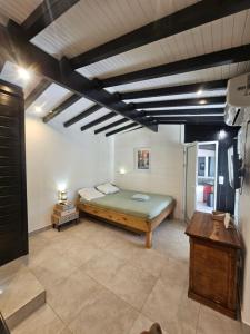 ein Schlafzimmer mit einem Bett in einem Zimmer in der Unterkunft Maison 80 m2 super vue montagne piscine 2 chambres in Goyave + 17 Fotos