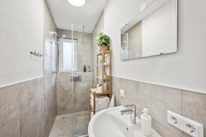a bathroom with a sink and a shower at KRelax - Bad Wildbad - Moderne Wohnung für 6 Pers in Bad Wildbad +14 photos