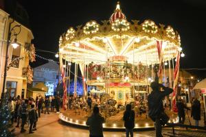 a group of people standing around a carousel at night at Homzy Craiova in Craiova