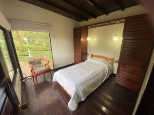 een slaapkamer met een bed, een raam en een stoel bij Condominio Hacienda Shangrila in San Francisco