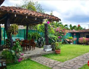 a garden with a wooden pergola and a table and chairs at Gran Bonanza Hotel in Alegría