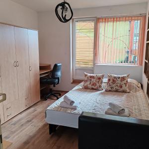una camera con letto, scrivania e finestra di Merak stan na dan a Vranje