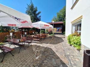 a patio with tables and chairs and umbrellas at Aparthotel Xavito in Sanok