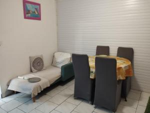 a room with a couch and a table and chairs at Petite Kaz KRÉOL in Basse-Terre