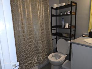 a bathroom with a toilet and a shower curtain at Simple entire apartment 2 bedroom night rest in Kitchener