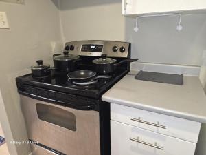 a kitchen with a stove with pots and pans on it at Simple entire apartment 2 bedroom night rest in Kitchener