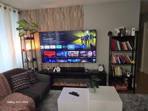a living room with a couch and a large screen tv at Simple entire apartment 2 bedroom night rest in Kitchener