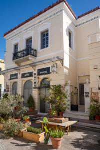 a white building with potted plants in front of it at The Saints Inn in Athens