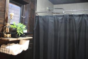 a bathroom with a shower with a black shower curtain at Cabañas Hacienda de Letras 