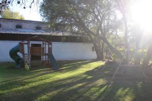 a yard with a swing set and a tree at Cabañas Hacienda de Letras  +40 photos