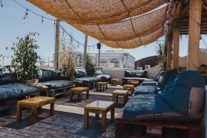 Un patio en la azotea con sofás y mesas. en LX Hostel, en Lisboa