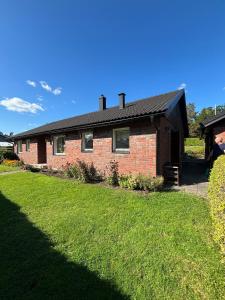 una casa di mattoni con un prato verde davanti di Kåhögsberget a Jonsered