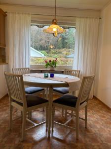 tavolo da pranzo con sedie e finestra di Kåhögsberget a Jonsered