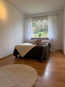 una camera da letto con un letto in una stanza con una finestra di Kåhögsberget a Jonsered Altre 12 foto