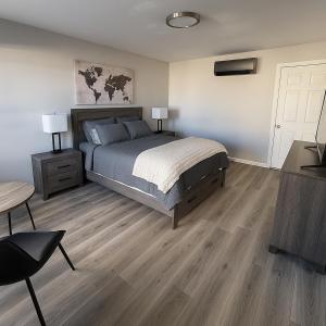 a bedroom with a bed and two lamps and a table at Empire Extended Stay in Webster +2 photos