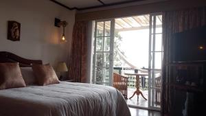 een slaapkamer met een bed en een glazen schuifdeur bij Condominio Hacienda Shangrila in San Francisco