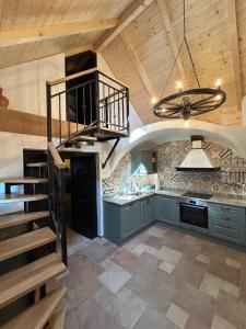 a kitchen with a spiral staircase in a kitchen at Balaton Cottage - Your Hide Away in Cserszegtomaj