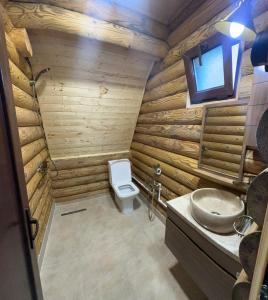 a wooden bathroom with a toilet and a sink at Borjomi-sadgeri comfort in Borjomi
