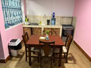 a small kitchen with a wooden table and chairs at Casa Azucena in Flores