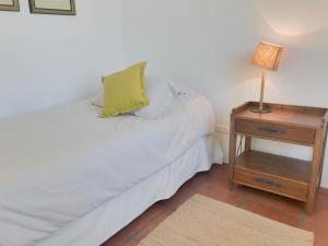 a bedroom with a bed and a night stand with a lamp at Casapueblo Rent Cachagua CP 05 in Cachagua
