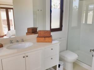 a bathroom with a sink and a toilet and a mirror at Casapueblo Rent Cachagua CP 05 in Cachagua +19 photos