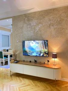 a living room with a large flat screen tv on a wall at Rustic Elegance Suite in Vrbas
