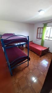 une chambre avec trois lits superposés et une fenêtre dans l'établissement La casa del pino, à Mina Clavero