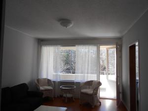 sala de estar con sofá, mesa y ventana en Laajavuori Apartment, en Jyväskylä