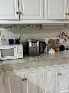 a kitchen counter with white cabinets and a microwave at Villa Haryouli in Azemmour